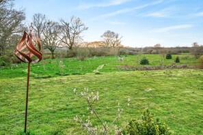 A grassy field with a metal sculpture, trees, and a clear sky. - 1 Bed in Sturminster Newton (oc-93841) (Hazelbury Bryan)