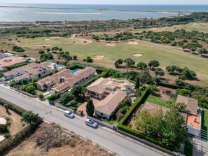 An aerial view of a residential area with houses, a road, and a golf course. - Villa Sea La Vie | Exclusive Villa with Private Pool near Palmares Golf Course (Vale da Lama - Odiáxere)