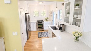 Een moderne keuken met witte kasten, roestvrijstalen apparatuur en een centraal kookeiland.