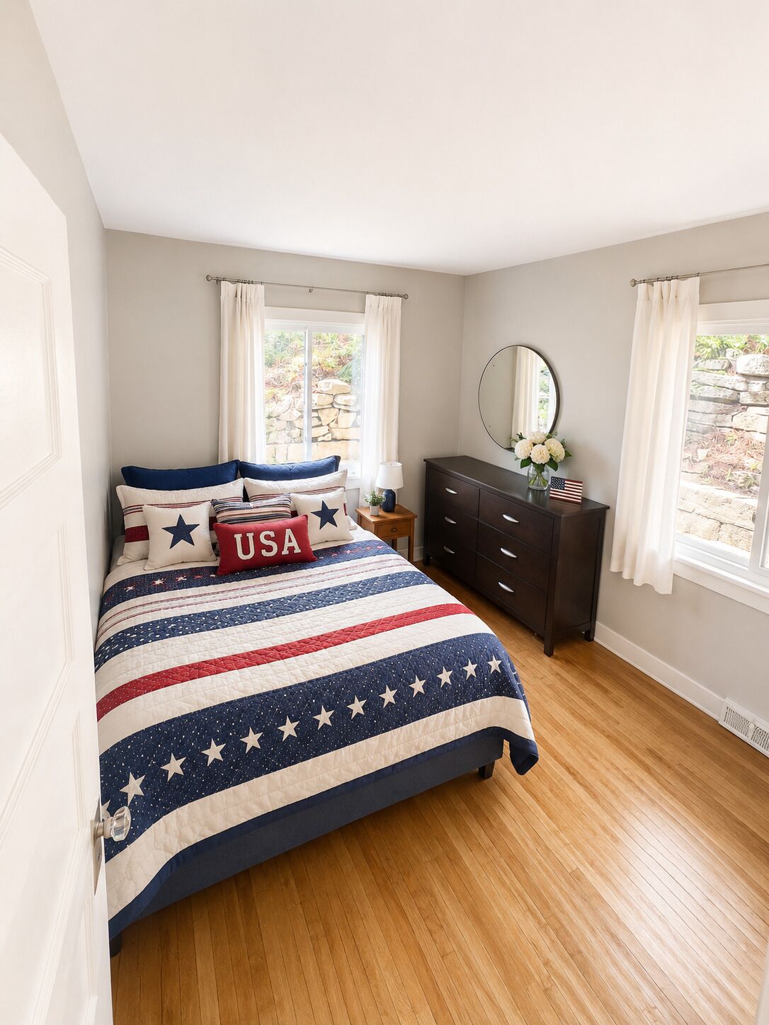 Un dormitorio con cama, cómoda, espejo y ventana con cortinas.