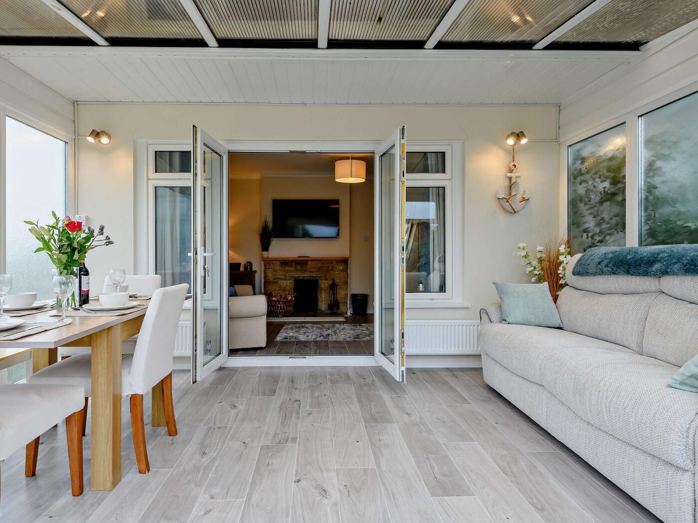 Ein modernes Wohnzimmer mit Essbereich, Kamin und großem Fenster.