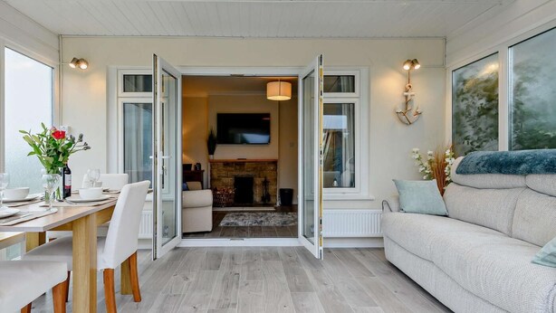 Ein modernes Wohnzimmer mit Essbereich, Kamin und großem Fenster.