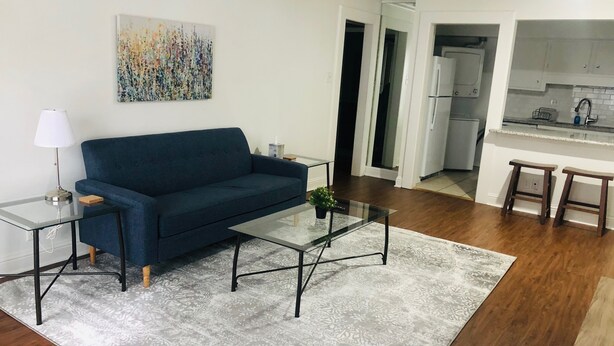 Un soggiorno con divano, tavolino e un quadro appeso al muro.