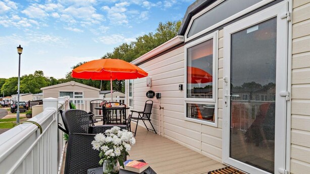 A deck with outdoor furniture, a table, and a chair. - 2 Bed in Sandown (oc-93900) (Sandown)