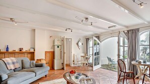 Una sala de estar con sofá, mesa de centro y un comedor con sillas y una mesa.