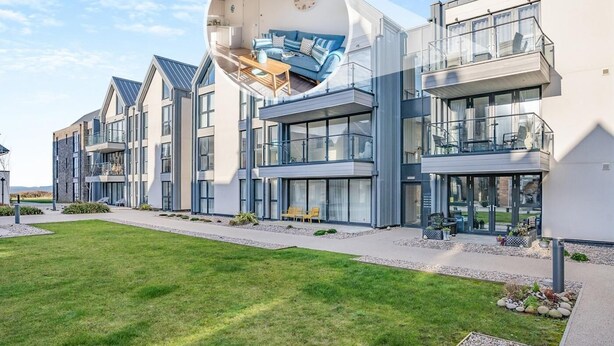 Un bâtiment moderne doté de nombreux balcons, de grandes fenêtres et d’une pelouse bien entretenue.