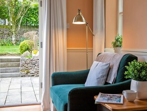 A cozy room with a teal sofa, a floor lamp, a potted plant, and a magazine on a wooden table. - 7 Bed in Buxton (oc-93808) (Tideswell)