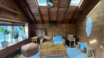 A wooden interior with a sofa, coffee table, and potted plants.