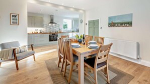 A modern kitchen with a dining area, wooden furniture, and a view of the outdoors. - 3 Bed in Barnard Castle (oc-93880) (Middleton-in-Teesdale)