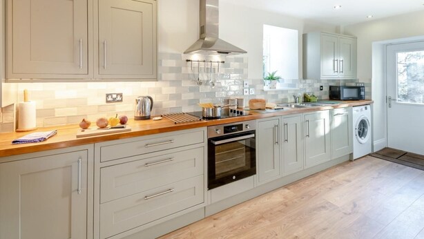 A modern kitchen with light-colored cabinets, a stainless steel range hood, and a built-in oven. - 3 Bed in Barnard Castle (oc-93880) (Middleton-in-Teesdale)