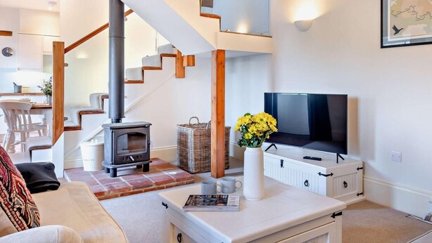 Una sala de estar moderna con una escalera, una chimenea, un televisor y un mapa en la pared.