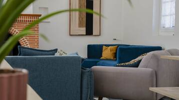 A living room with a blue sofa, a grey armchair, and a wooden coffee table.