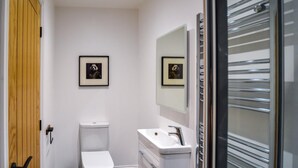 Ein Badezimmer mit Toilette, Waschbecken und zwei gerahmten Bildern an der Wand.