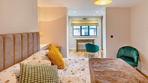 A bedroom with a bed, a desk, a chair, and a sofa. - 1 Bed in Woolacombe (oc-93920) (Woolacombe)
