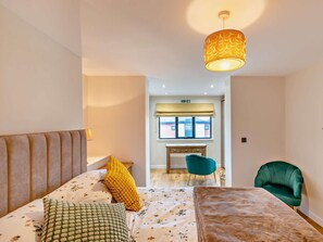 Ein Schlafzimmer mit Bett, Schreibtisch, Stuhl und Schlafsofa.