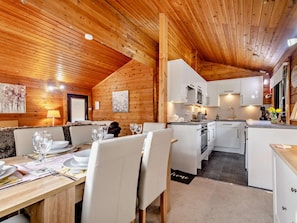 A cozy cabin interior with a dining area, kitchen, and a loft bedroom. - 3 Bed in Dalbeattie (oc-93985) (Sandyhills)
