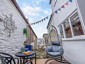 A patio area with a round table, chairs, and a hanging chair. - 2 Bed in Brixham (oc-93990) (Brixham)