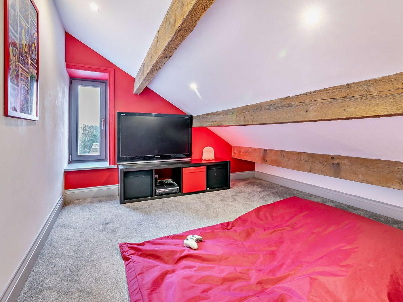 A bedroom with a television, a bed, and a window.