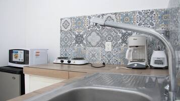 Une cuisine équipée d’un évier, d’une cuisinière et d’une machine à café.