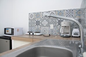 A kitchen with a sink, stove, and coffee maker. - Isla Venados Renta Vacacional (Mazatlán)