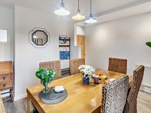 A dining area with a wooden table, woven chairs, and pendant lighting. - 3 Bed in Cowes (oc-93982) (Cowes)