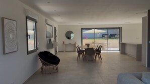 Una cocina moderna con comedor, ventanas amplias y vistas al exterior.