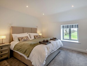 A bedroom with a bed, nightstands, a window, and a view of the outdoors. - 4 Bed in Brough (oc-93496) (Brough)