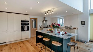 A modern kitchen with a central island, wooden flooring, and recessed lighting. - 4 Bed in Brough (oc-93496) (Brough)