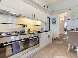 A modern kitchen with stainless steel appliances, white cabinetry, and a visible Bosch oven. - 4 Bed in Torquay (oc-94002) (Torquay)