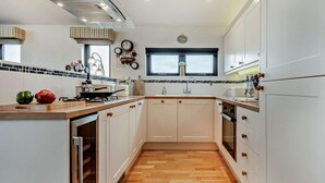 A modern kitchen with white cabinets, a wooden countertop, and a built-in oven.