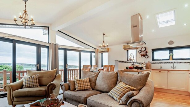 A spacious living area with a sofa set, a wooden coffee table, and a view of the outdoors.