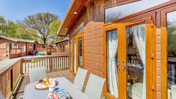 A wooden deck with a table and chairs, a dining set, and a board game.