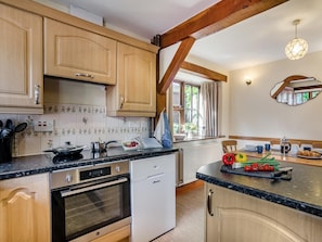 A kitchen with wooden cabinets, a stove, a dishwasher, and a window with curtains. - 2 Bed in Hereford (oc-94018) (Dorstone)