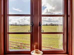 A window with a view of a grassy field and a cloudy sky. - 3 Bed in Great Yarmouth (oc-94054) (Repps with Bastwick)