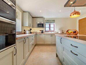 A modern kitchen with a microwave, toaster, kettle, and a fruit bowl on the counter. - 3 Bed in Great Yarmouth (oc-94054) (Repps with Bastwick)