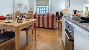 Ett modernt kök med matplats, trägolv och ett stort fönster.