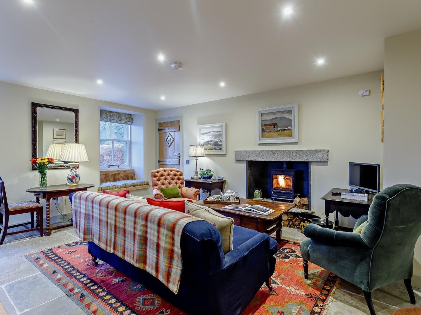 A cozy living room with a fireplace, comfortable seating, and a television.