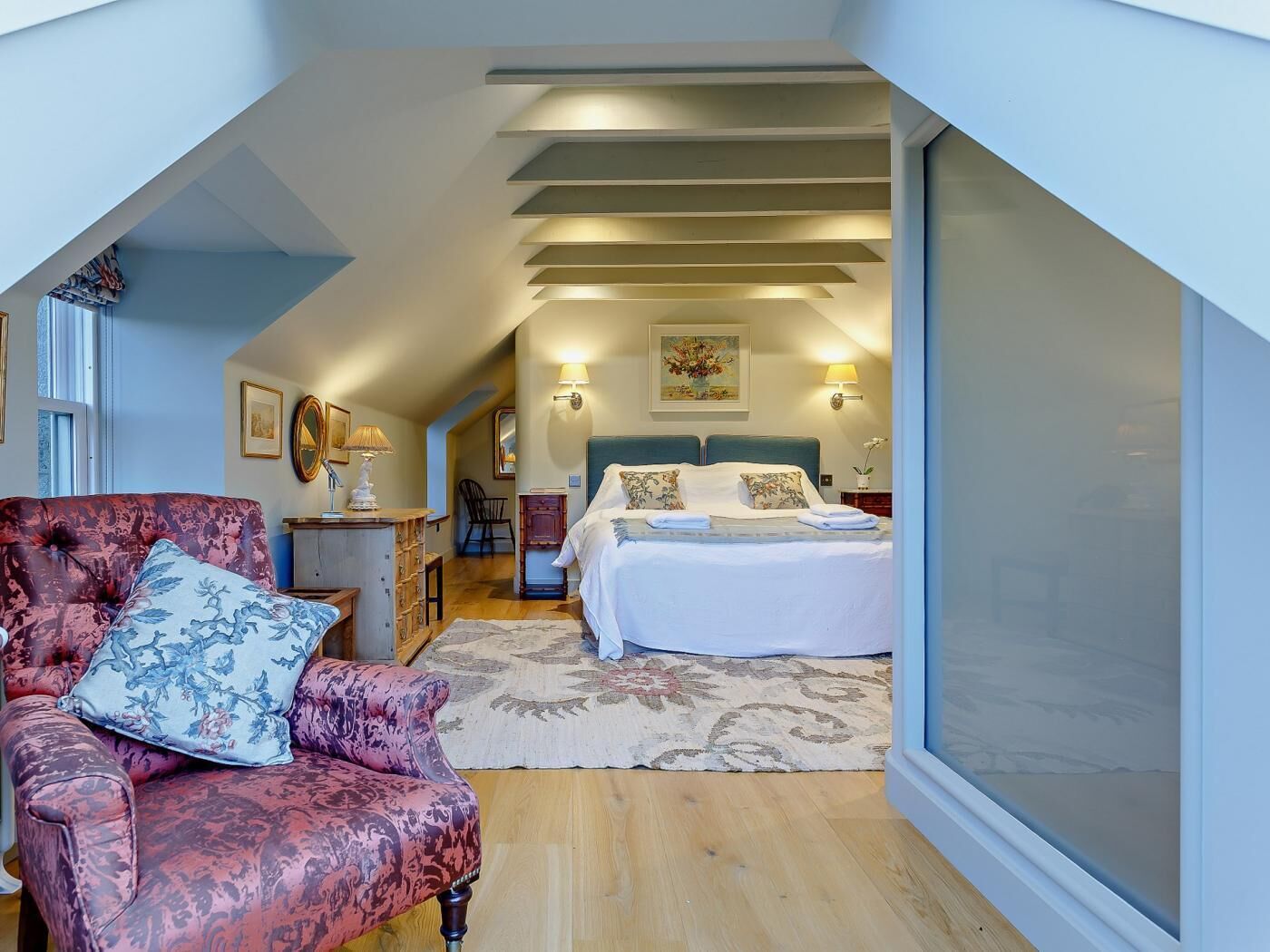 Une chambre à coucher avec un lit, une chaise et une table de chevet.