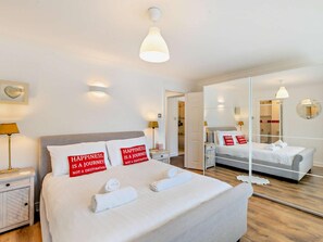 A hotel room with a large bed, two bedside tables, a bedside lamp, a mirror, and a view of the bathroom. - 2 Bed in Stratford -upon- Avon (oc-41540) (Stratford-upon-Avon)