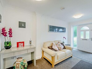A modern living room with a beige sofa, a white console table, and a framed picture on the wall. - 2 Bed in Stratford -upon- Avon (oc-41540) (Stratford-upon-Avon)