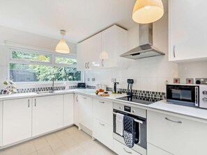 A modern kitchen with white cabinetry, a black induction cooktop, a built-in oven, and a microwave. - 2 Bed in Stratford -upon- Avon (oc-41540) (Stratford-upon-Avon)