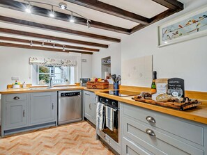A modern kitchen with grey cabinets, a wooden countertop, and a herringbone floor pattern. - 2 Bed in York (oc-93614) (Beadlam)