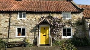 A stone house with a yellow door, a tiled roof, and a chimney. - 2 Bed in York (oc-93614) (Beadlam)