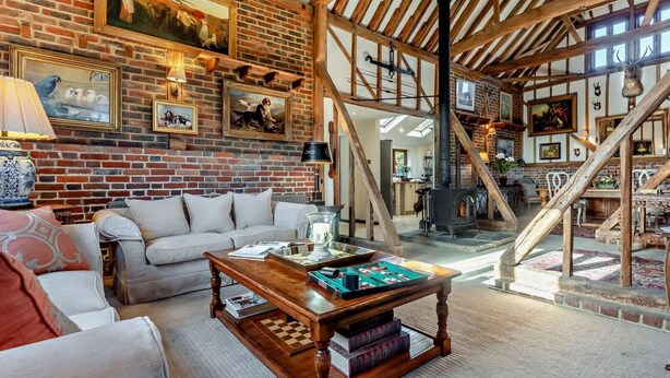 Un intérieur rustique avec des poutres apparentes, un mur en briques et une cheminée.