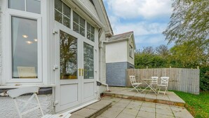 Il s’agit d’une propriété résidentielle dotée d’une terrasse, de fenêtres à cadre blanc et d’une clôture en bois.