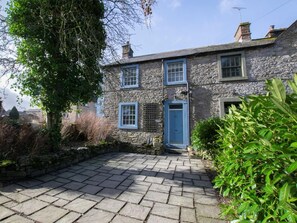 A stone building with a blue door and windows, surrounded by greenery. - 3 Bed in Penrith (oc-74159) (Shap)