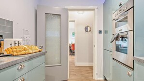 Une cuisine moderne avec un pain sur le comptoir, un grille-pain et un four en acier inoxydable.