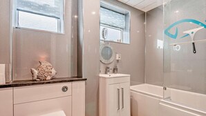Une salle de bain moderne équipée de toilettes, d’un lavabo et d’une baignoire.
