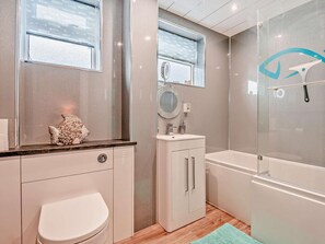 A modern bathroom with a toilet, sink, and bathtub. - 2 Bed in Swanage (oc-93542) (Swanage)