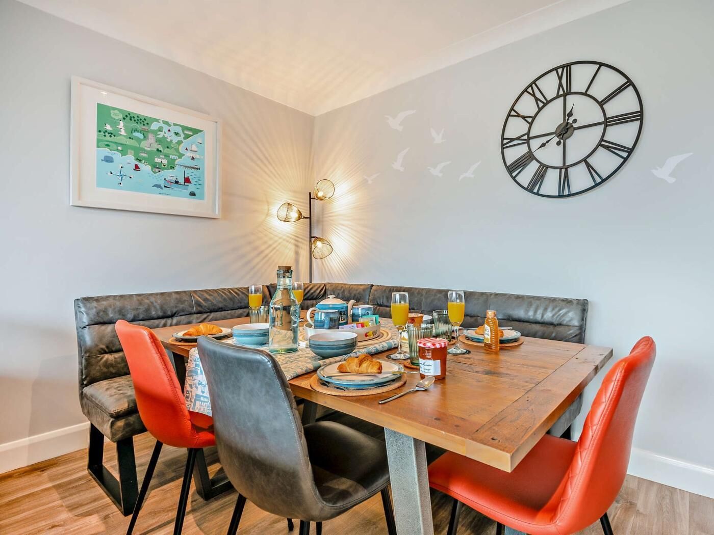 Een eetgedeelte met een houten tafel, lederen stoelen en een klok aan de muur.